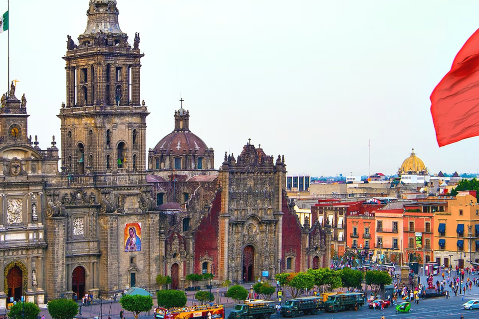 A small plaza in Mexico with people passing through warm afternoon light